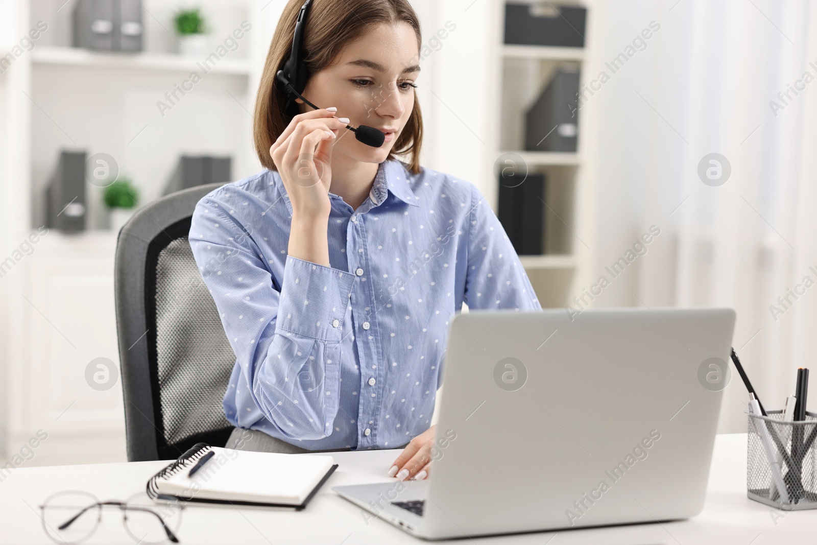 Photo of Teenager in headset having video chat via laptop at home. Remote work