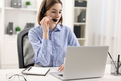 Teenager in headset having video chat via laptop at home. Remote work