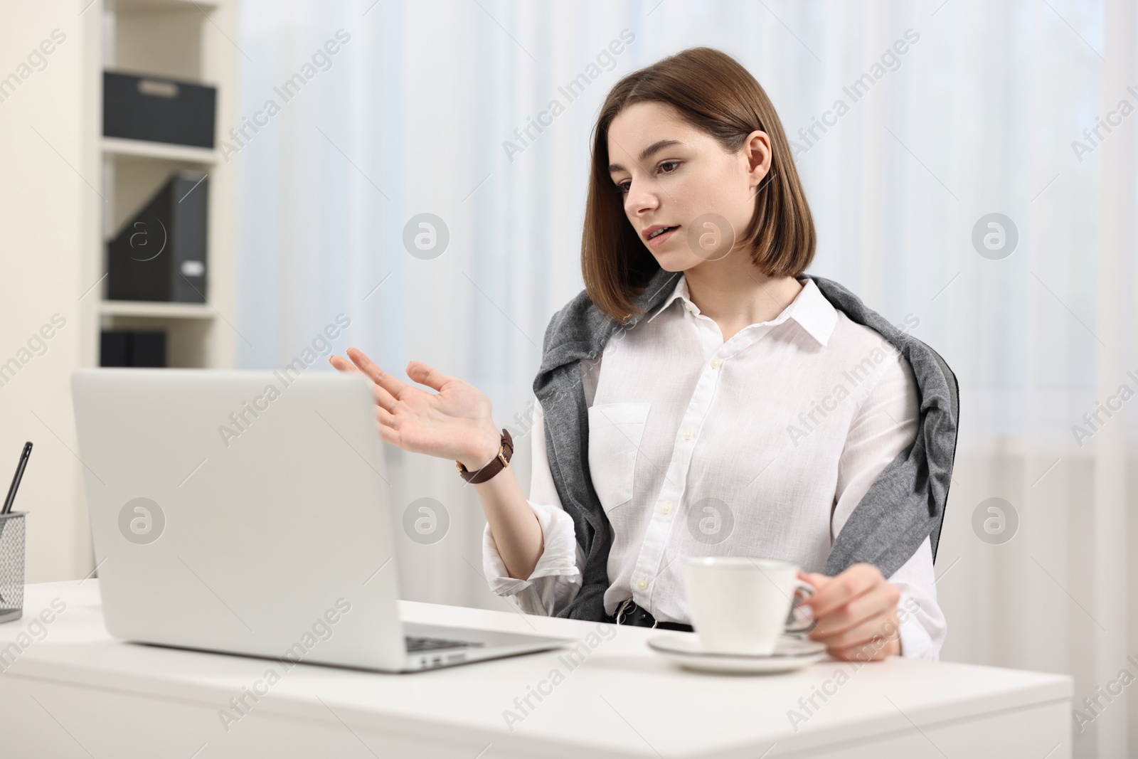 Photo of Teenager having video chat via laptop at home. Remote work