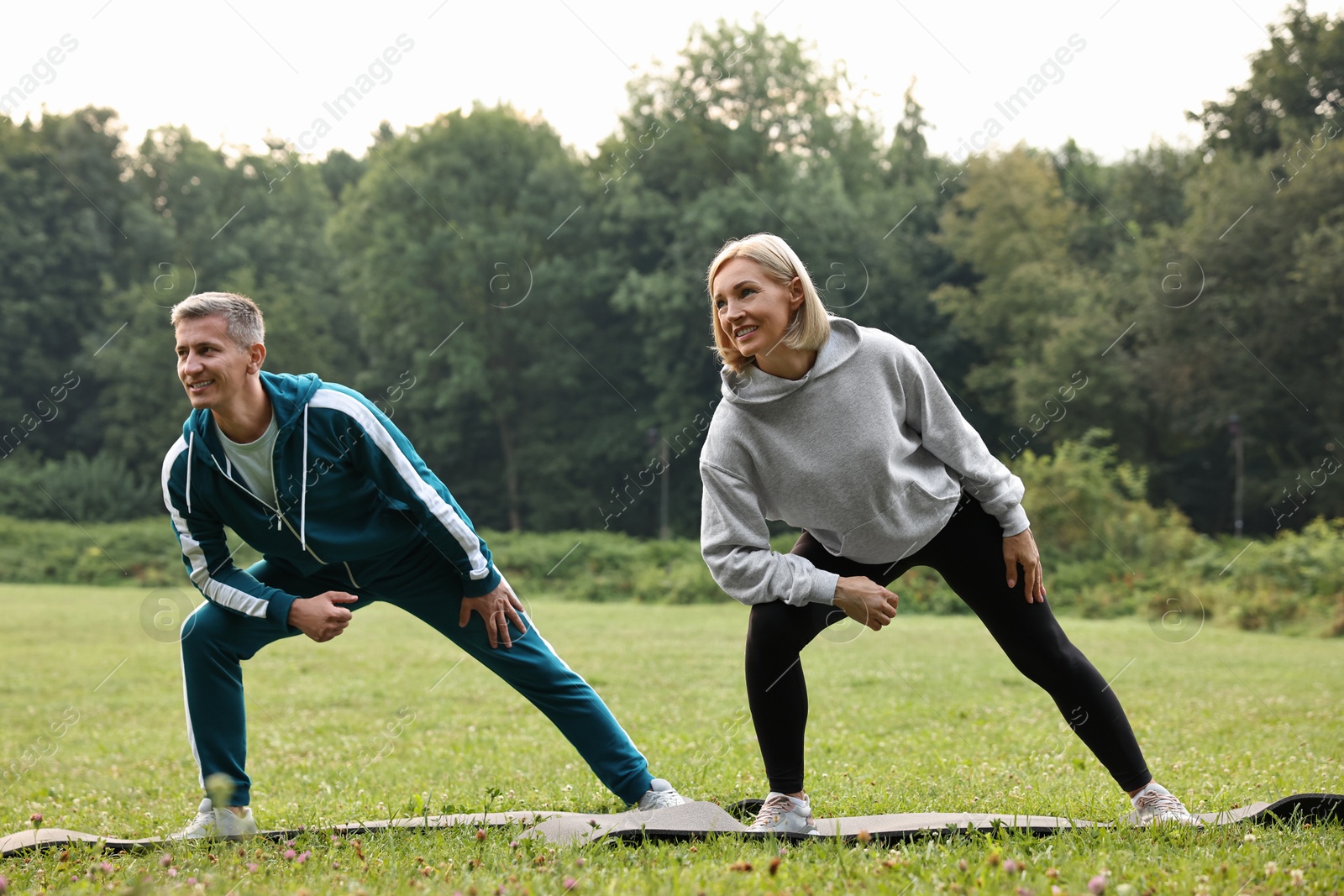 Photo of Happy couple doing exercises in park. Healthy lifestyle