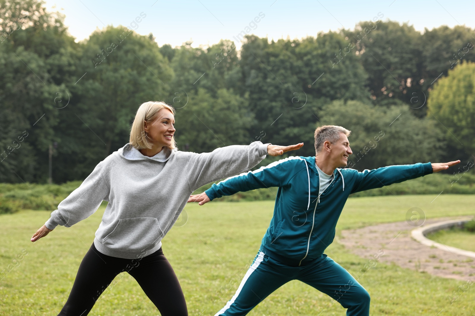 Photo of Happy couple doing exercises in park. Healthy lifestyle