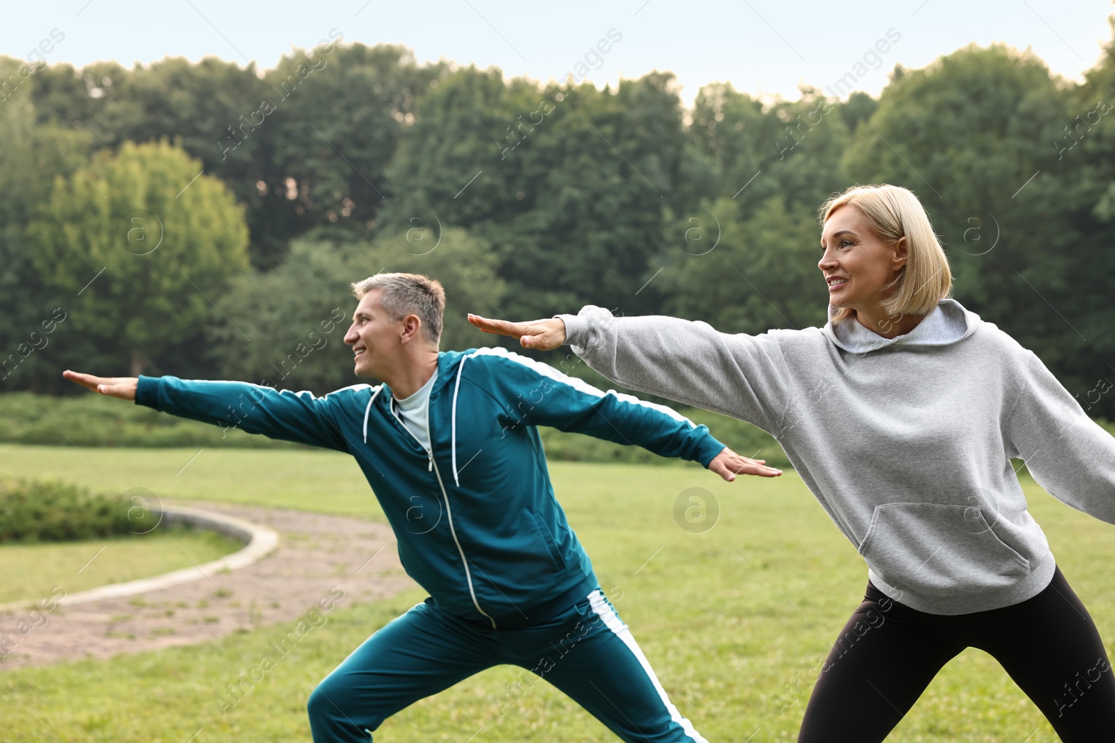 Photo of Happy couple doing exercises in park. Healthy lifestyle