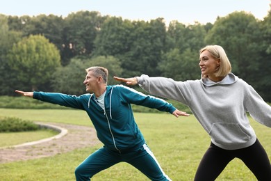 Photo of Happy couple doing exercises in park. Healthy lifestyle