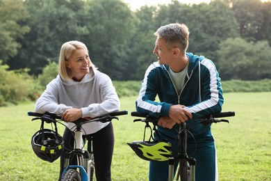 Photo of Happy couple with bicycles in park. Healthy lifestyle