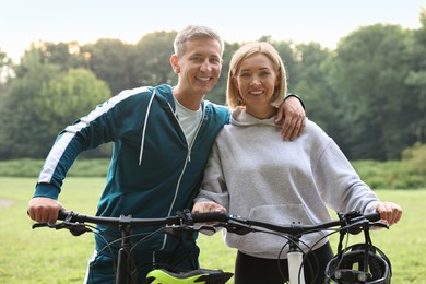 Happy couple with bicycles in park. Healthy lifestyle