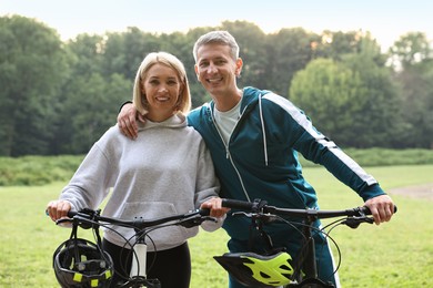 Happy couple with bicycles in park. Healthy lifestyle