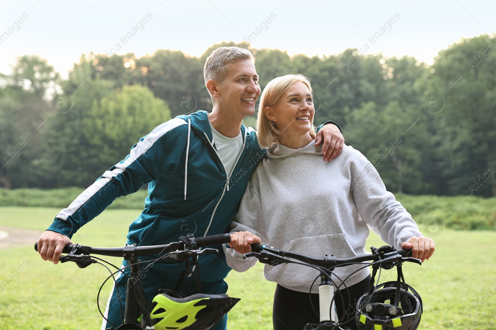 Photo of Happy couple with bicycles in park. Healthy lifestyle