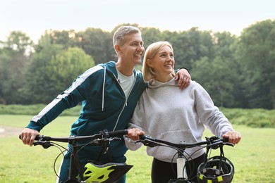 Photo of Happy couple with bicycles in park. Healthy lifestyle