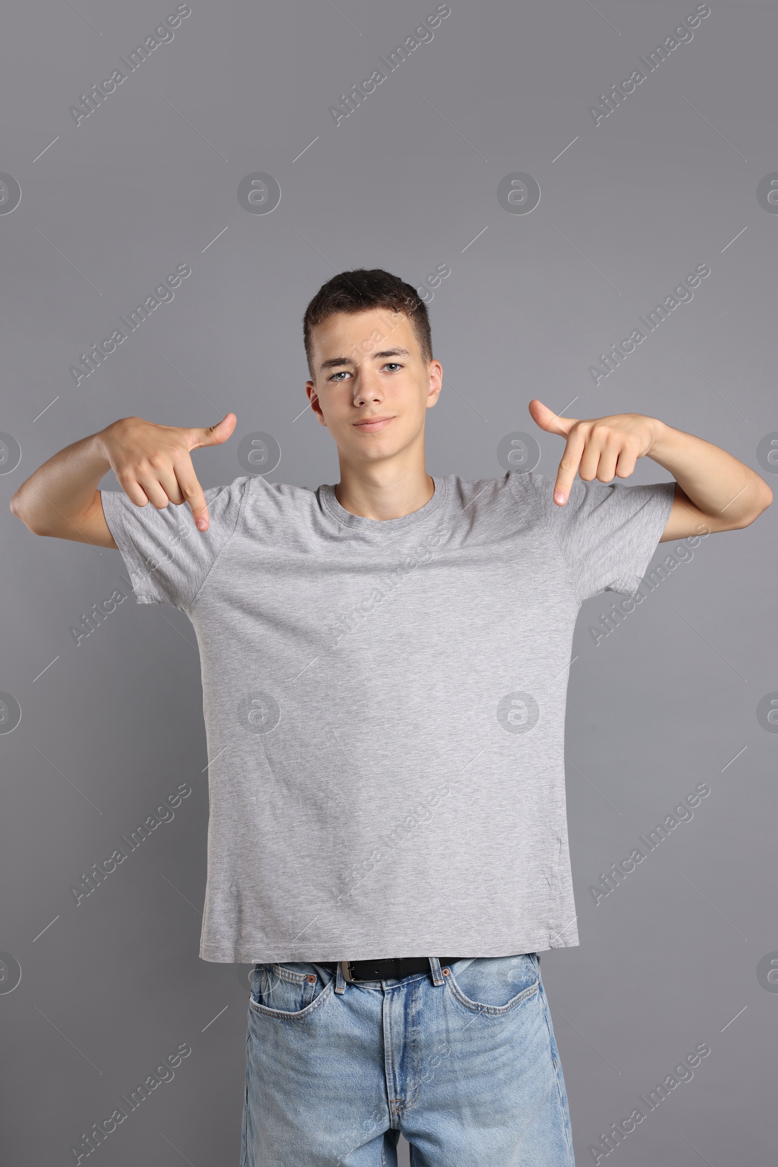 Photo of Teenage boy wearing t-shirt on grey background