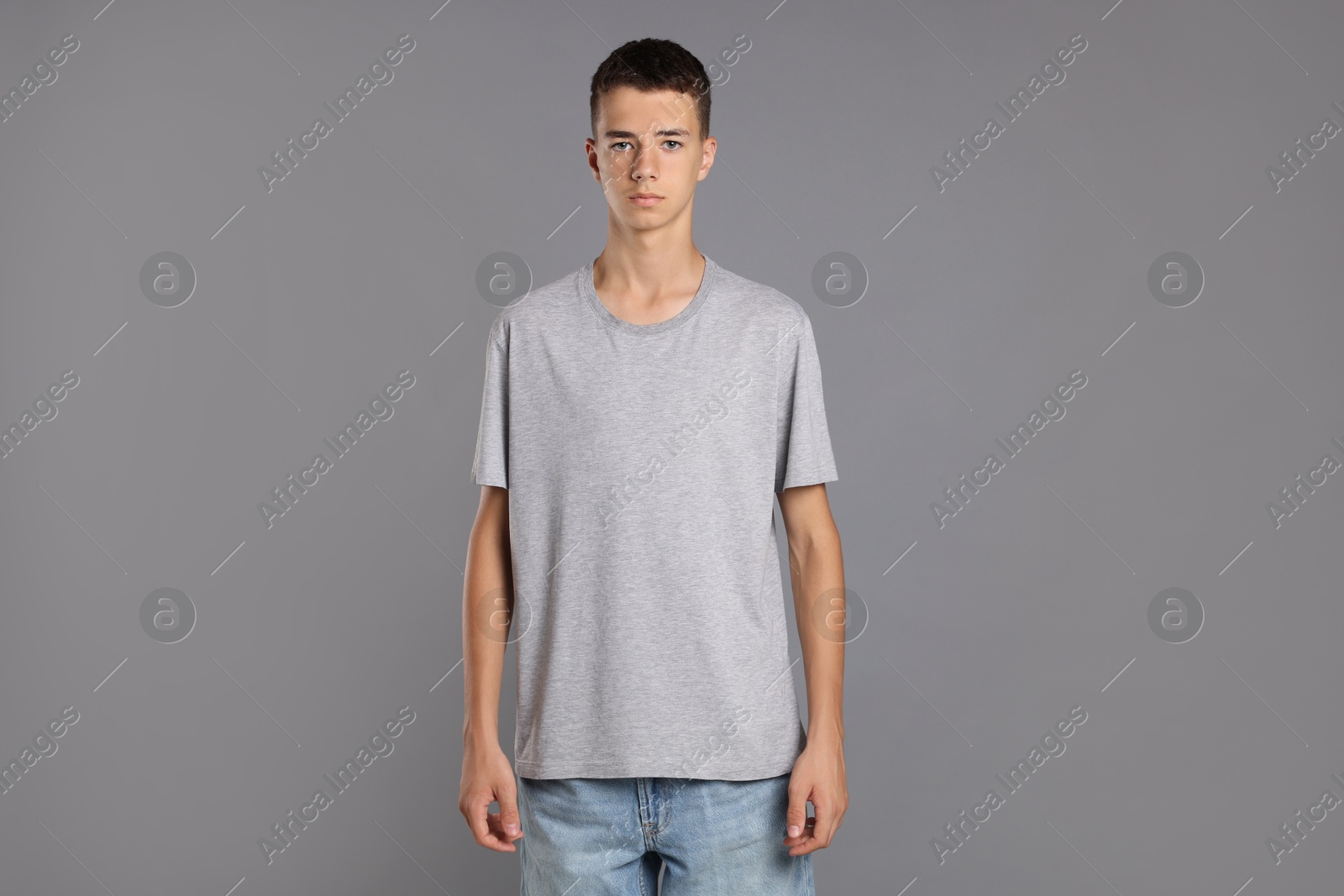 Photo of Teenage boy wearing t-shirt on grey background