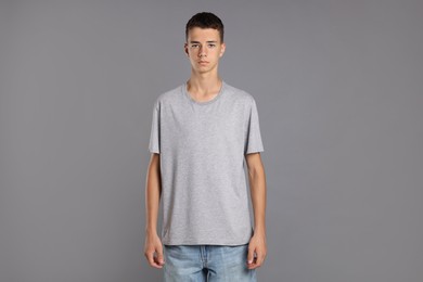 Teenage boy wearing t-shirt on grey background