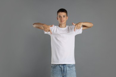 Photo of Teenage boy wearing white t-shirt on grey background