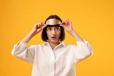 Overslept young woman with sleep mask on yellow background