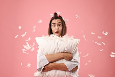 Photo of Overslept young woman with pillow on pink background