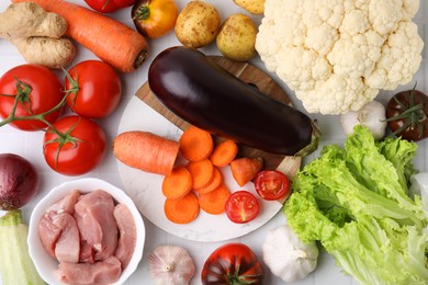 Photo of Different vegetables and raw meat for stew on table, top view