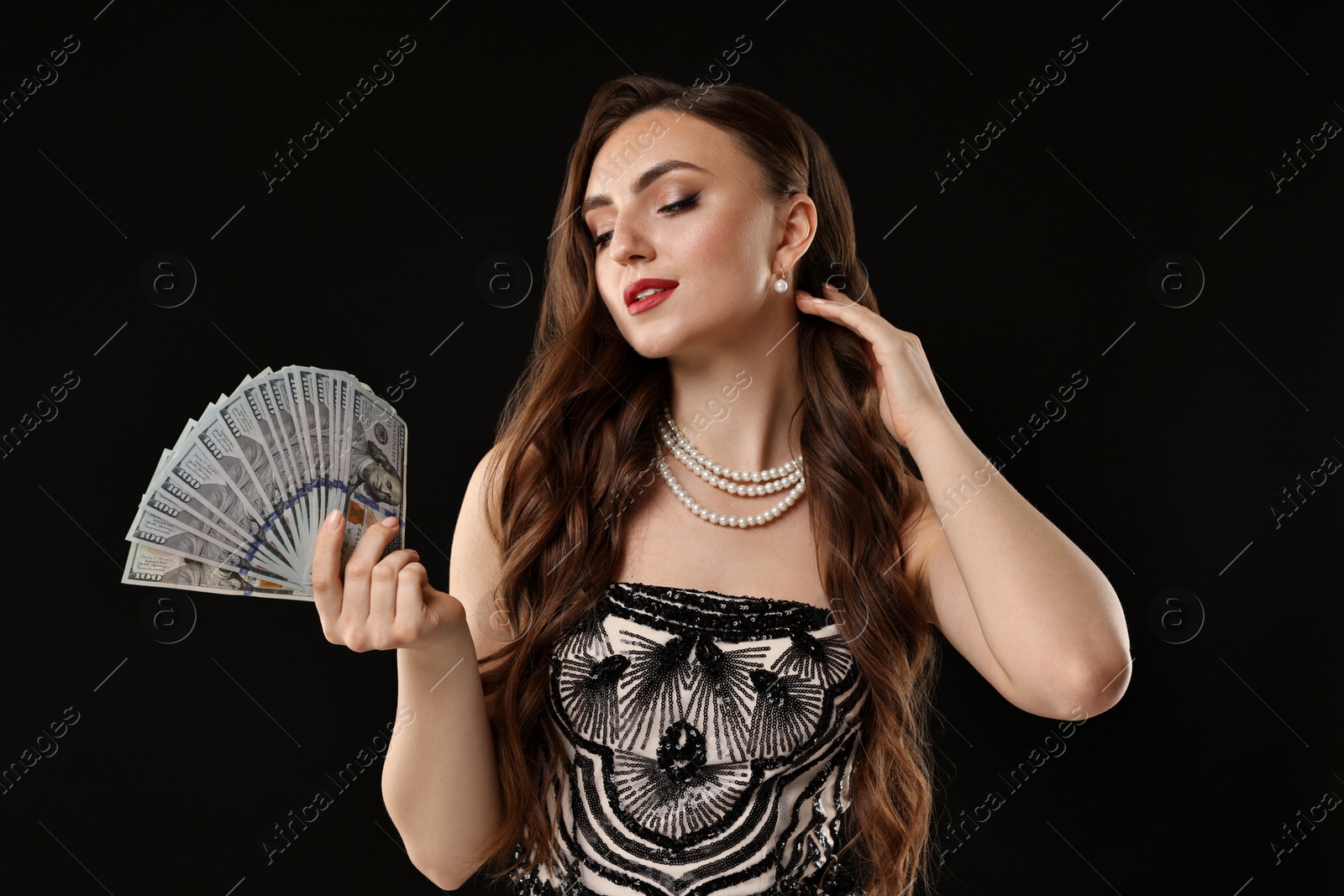 Photo of Charming woman with dollar banknotes on black background