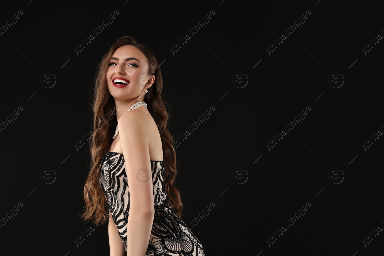 Photo of Portrait of happy woman on black background. Space for text