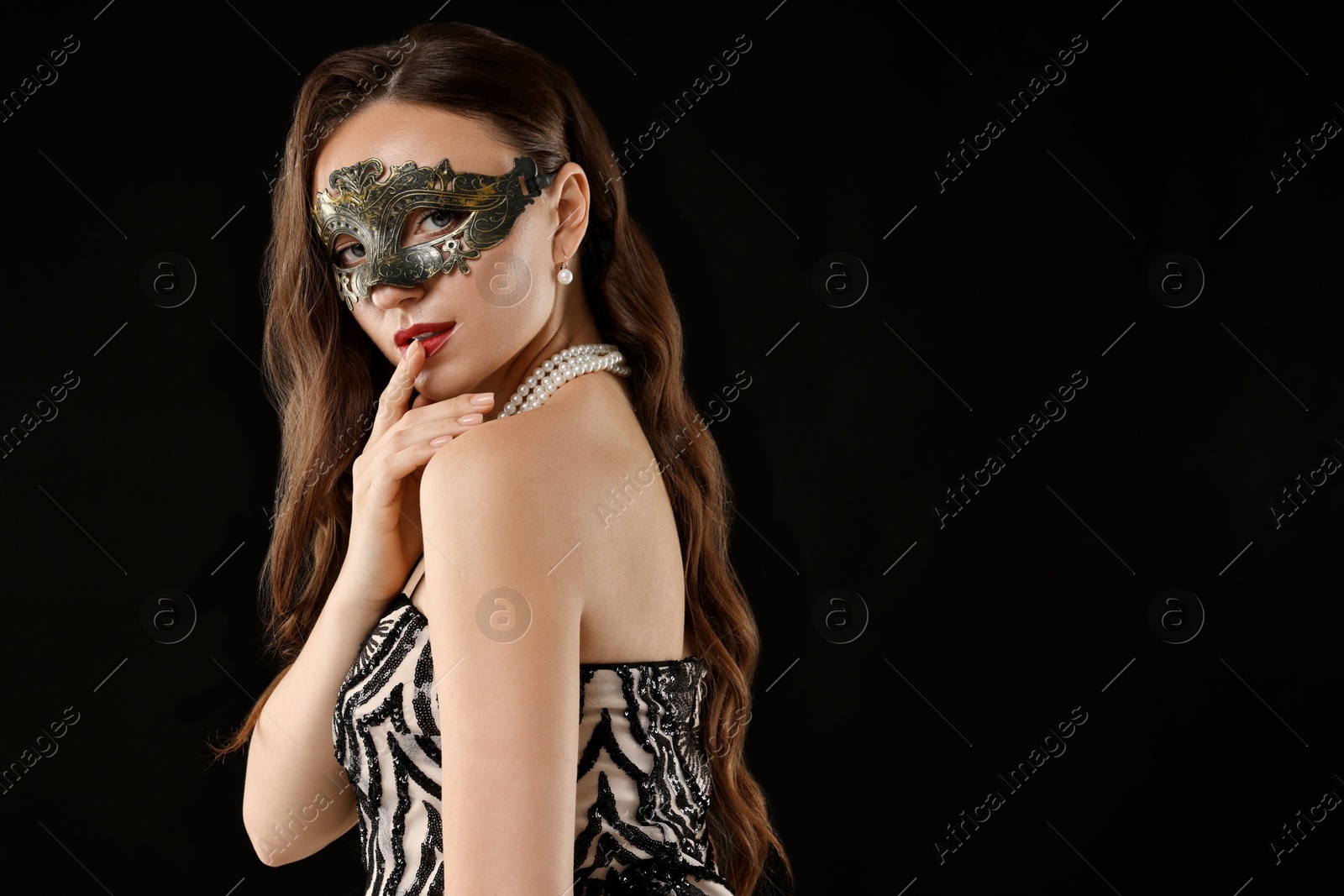 Photo of Beautiful woman wearing carnival mask on black background. Space for text