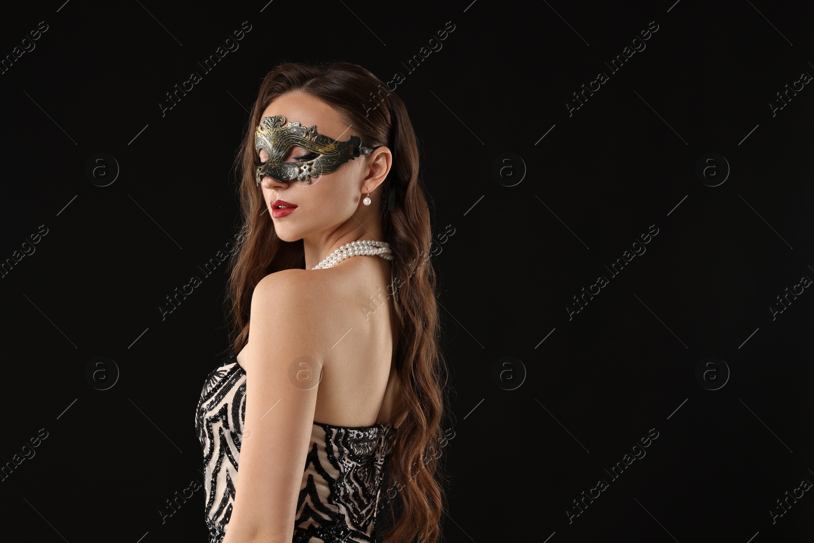 Photo of Beautiful woman wearing carnival mask on black background. Space for text