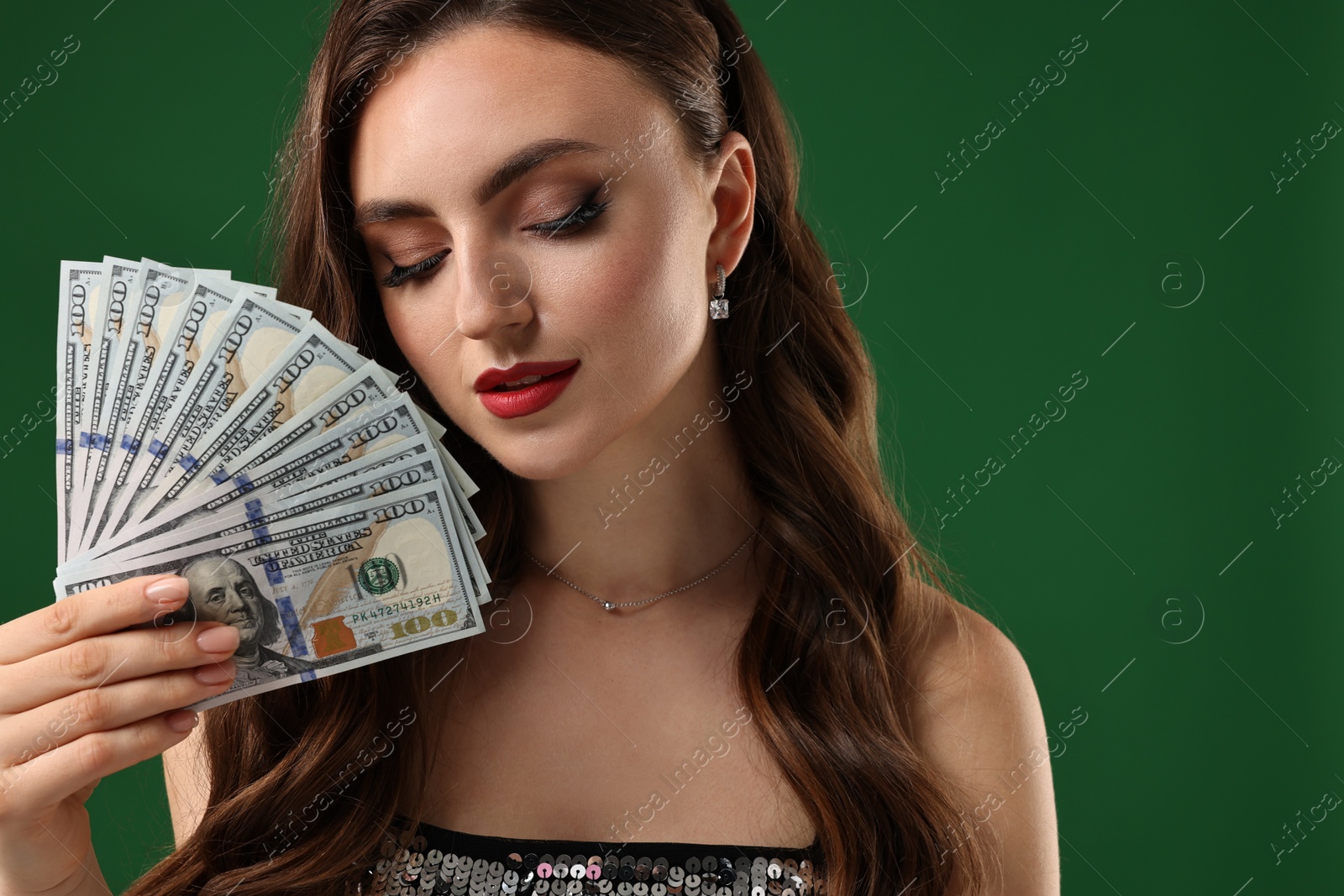 Photo of Charming woman with dollar banknotes on green background