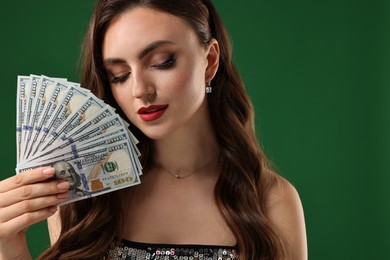 Charming woman with dollar banknotes on green background