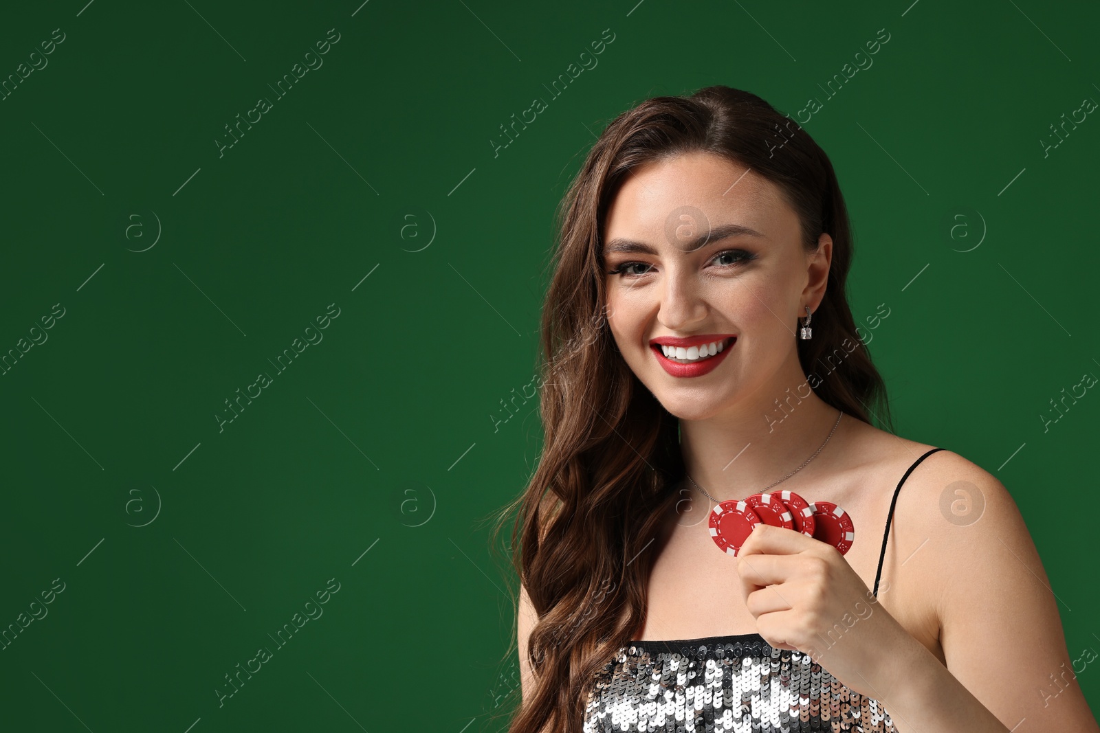 Photo of Smiling woman with poker chips on green background. Space for text