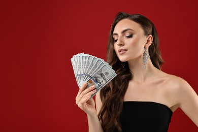 Photo of Charming woman with dollar banknotes on red background. Space for text