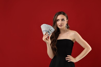 Photo of Charming woman with dollar banknotes on red background. Space for text