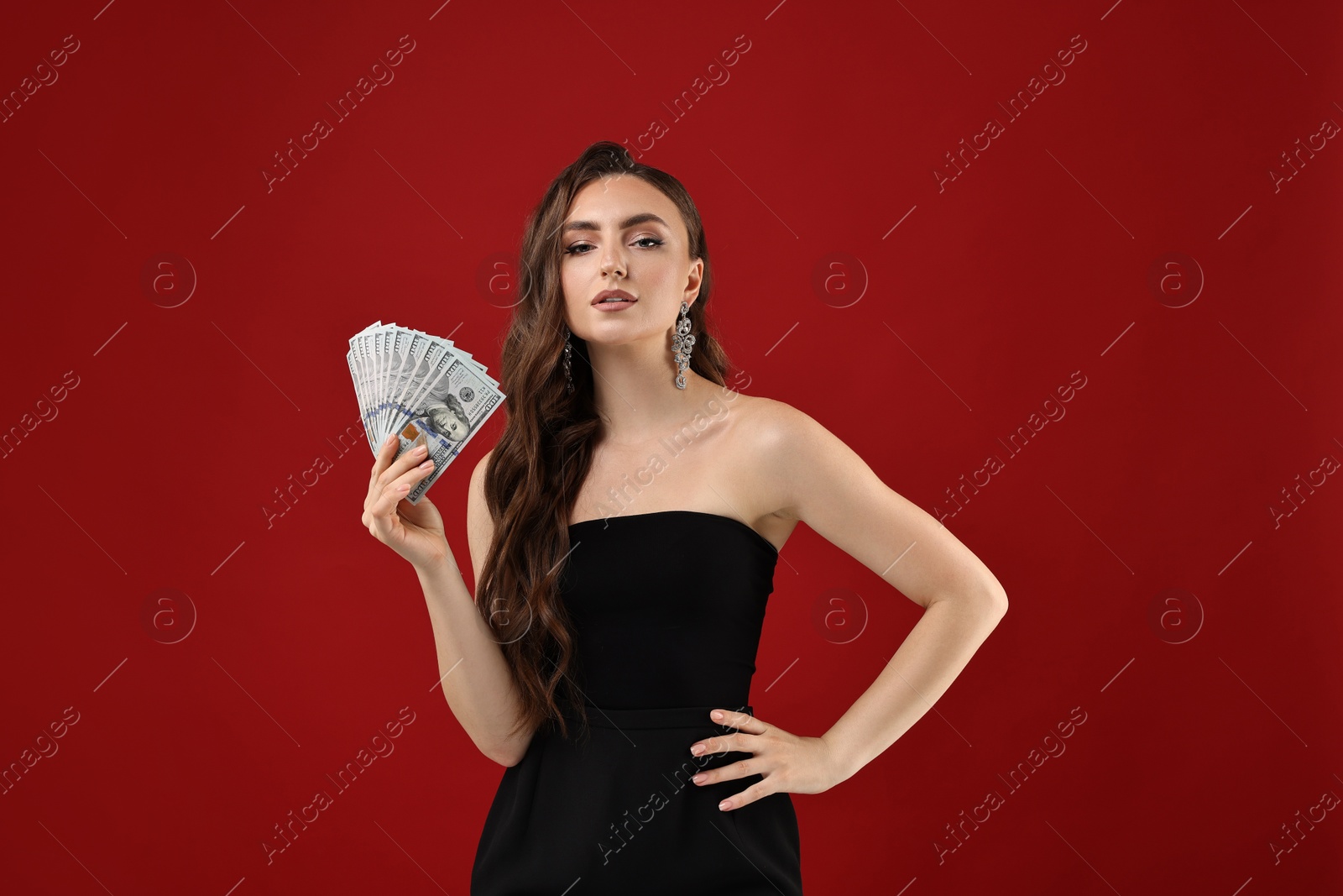 Photo of Charming woman with dollar banknotes on red background