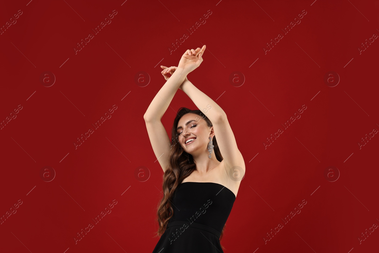 Photo of Portrait of smiling woman dancing on red background