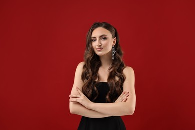 Photo of Portrait of charming woman with crossed arms on red background