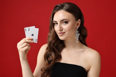 Photo of Poker game. Charming woman with playing cards on red background