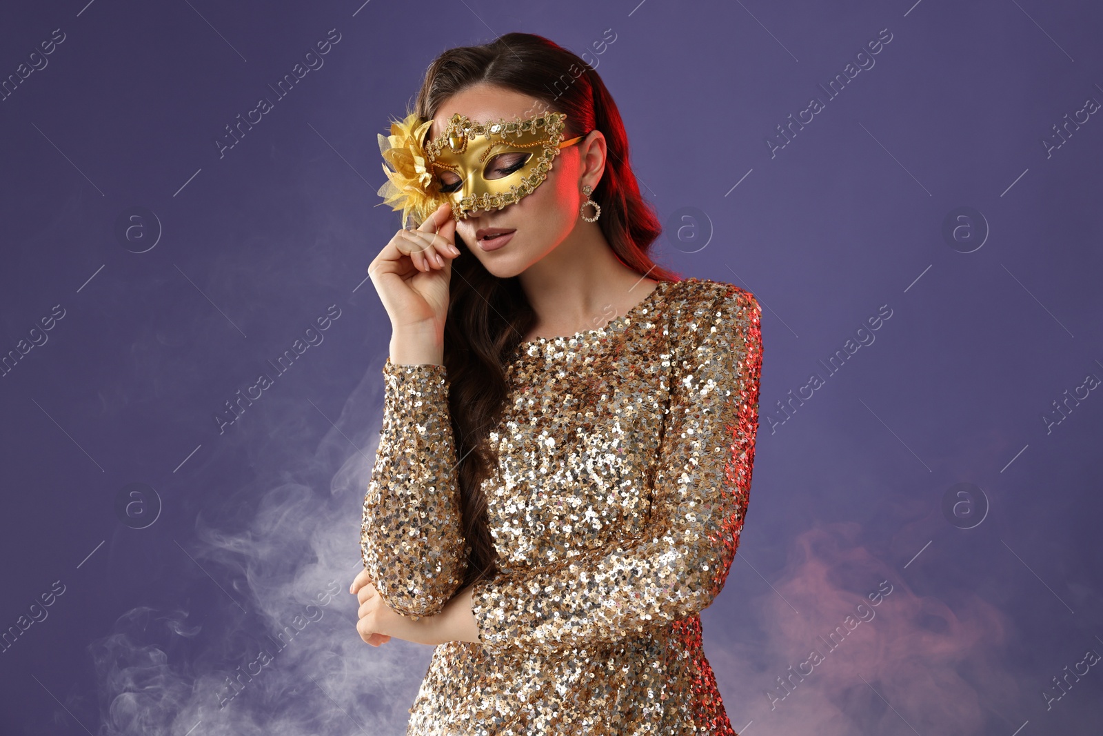 Photo of Beautiful woman wearing carnival mask on purple background with smoke