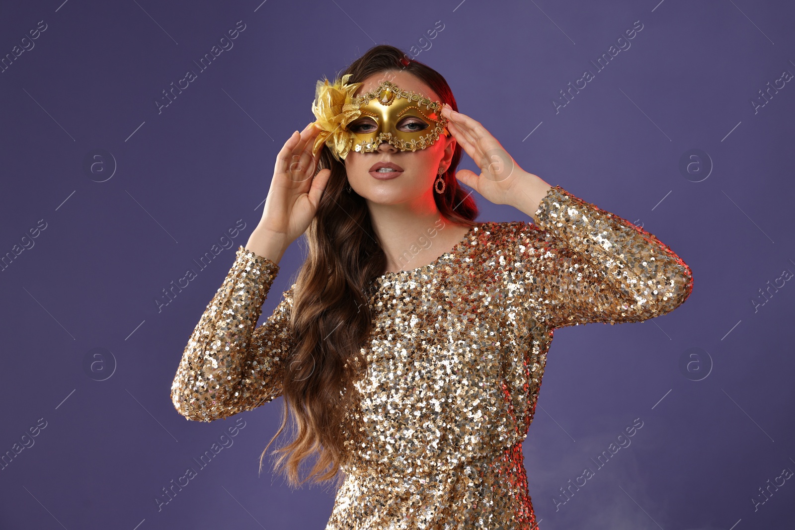 Photo of Beautiful woman wearing carnival mask on purple background with smoke