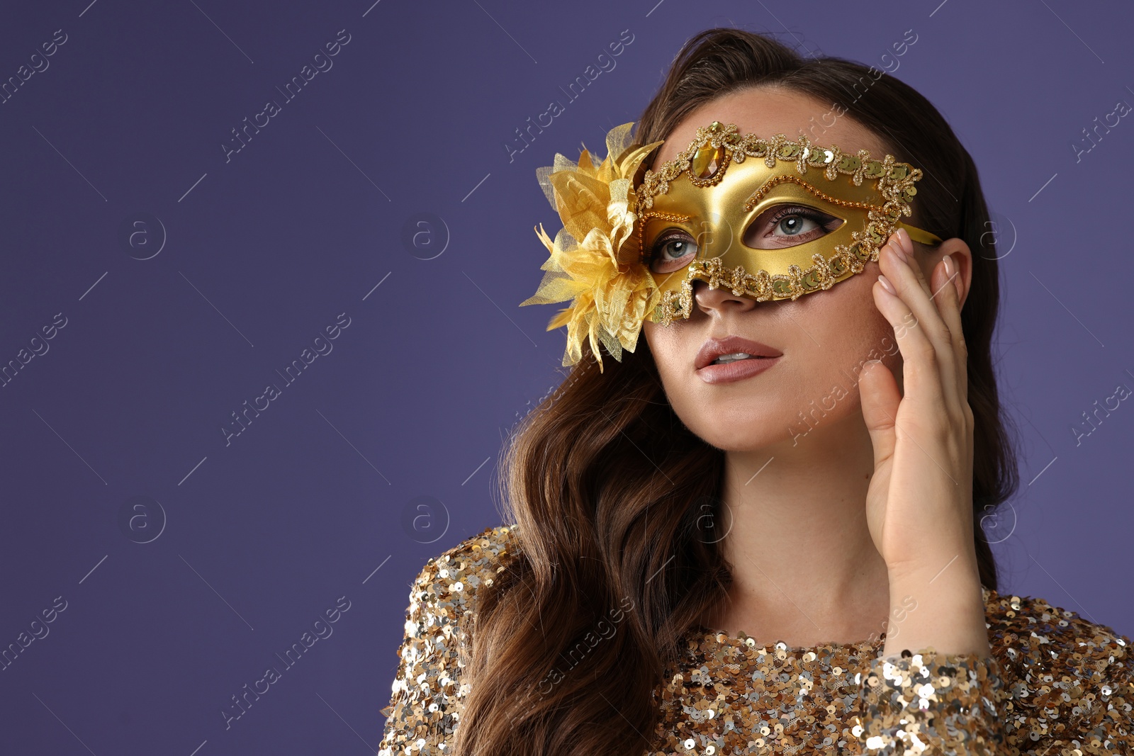 Photo of Beautiful woman wearing carnival mask on purple background, closeup. Space for text