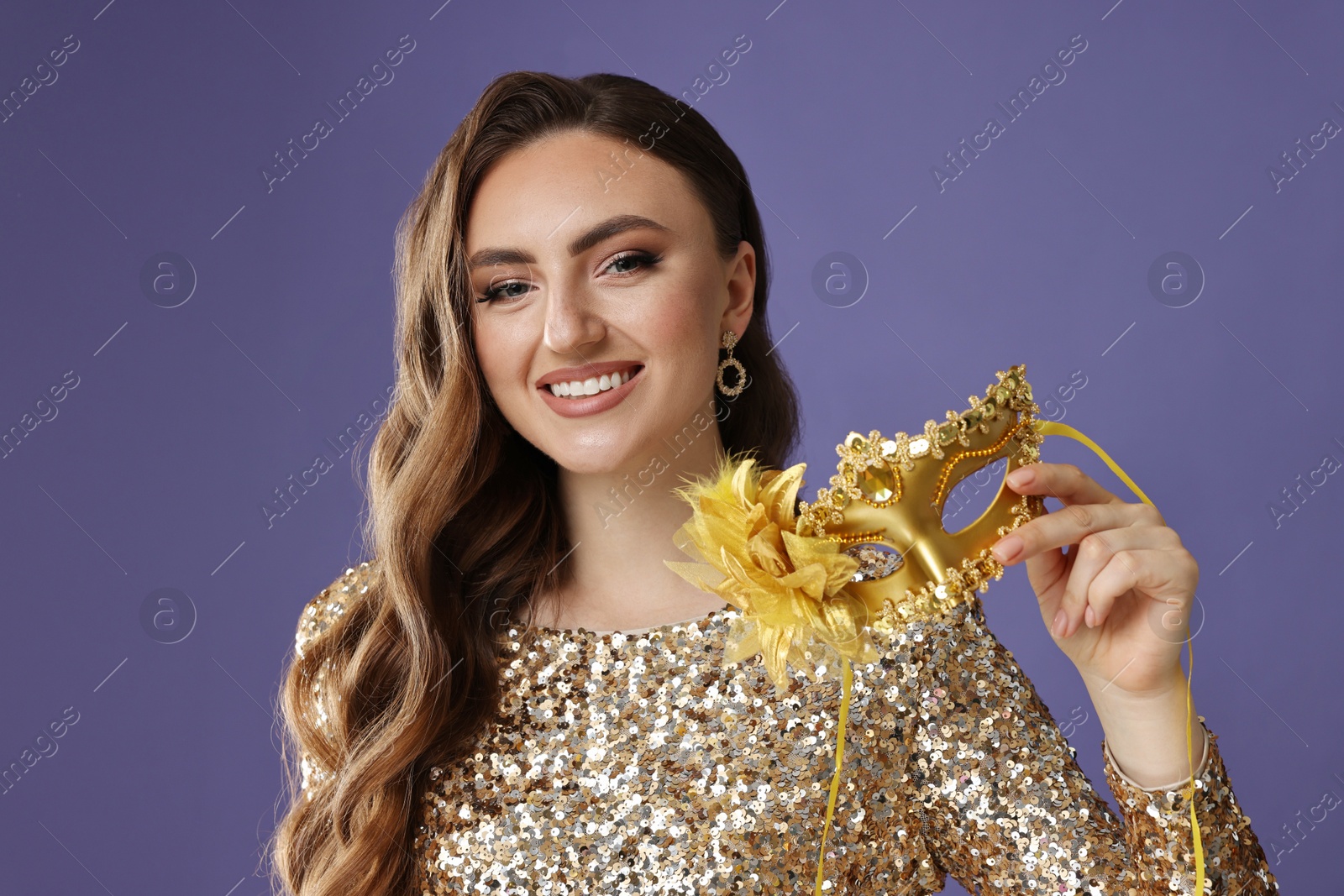 Photo of Smiling woman with carnival mask on purple background