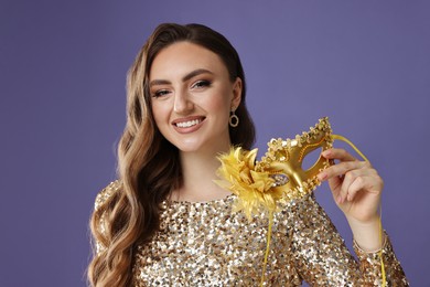 Smiling woman with carnival mask on purple background