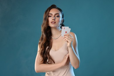 Photo of Poker game. Charming woman with playing cards on light blue background