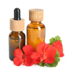 Photo of Bottles of geranium essential oil and beautiful flowers isolated on white