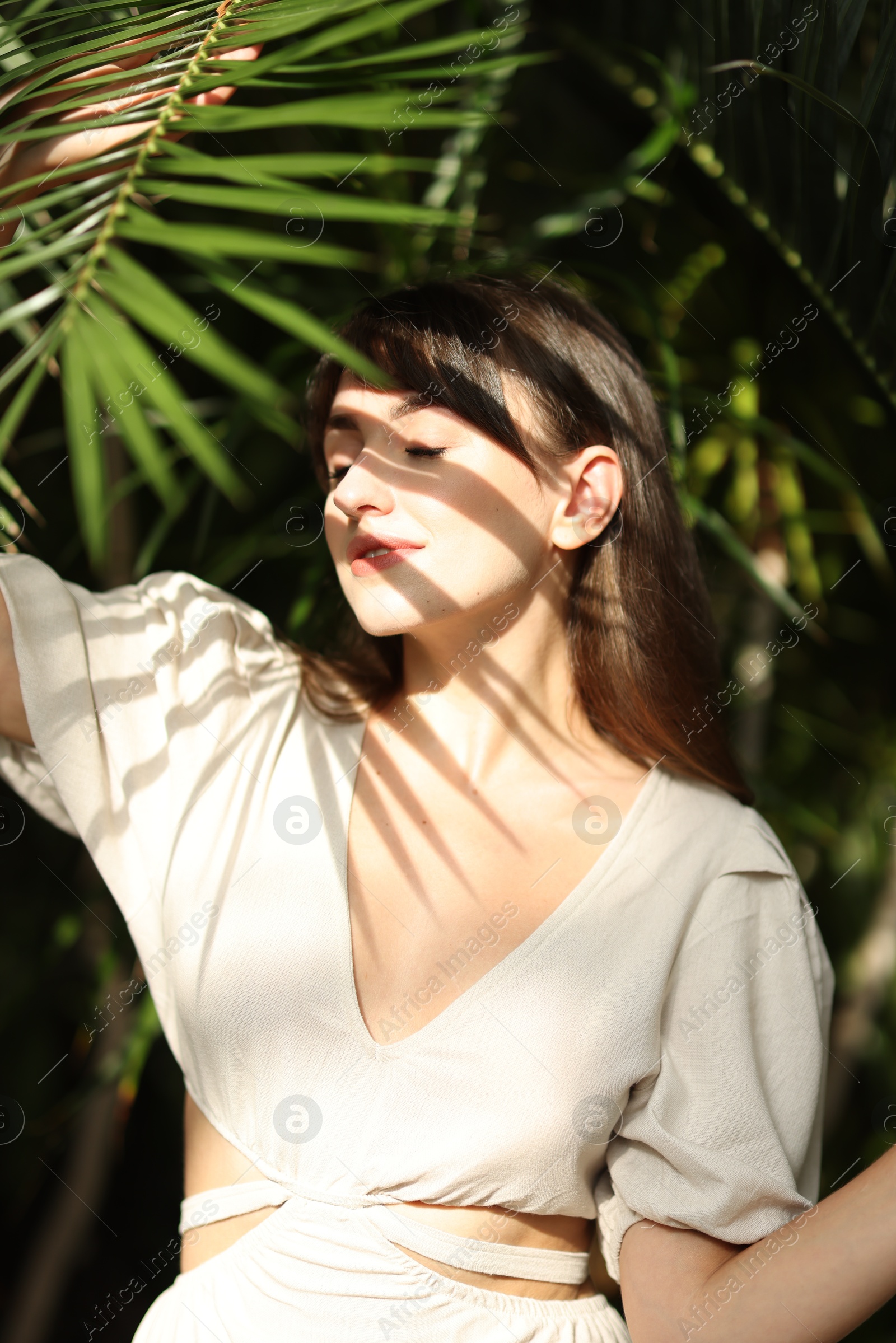 Photo of Portrait of beautiful woman in shadow of tropical leaf outdoors