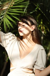 Photo of Portrait of beautiful woman in shadow of tropical leaf outdoors