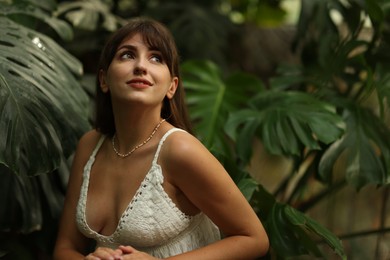 Portrait of smiling woman in tropical forest. Space for text