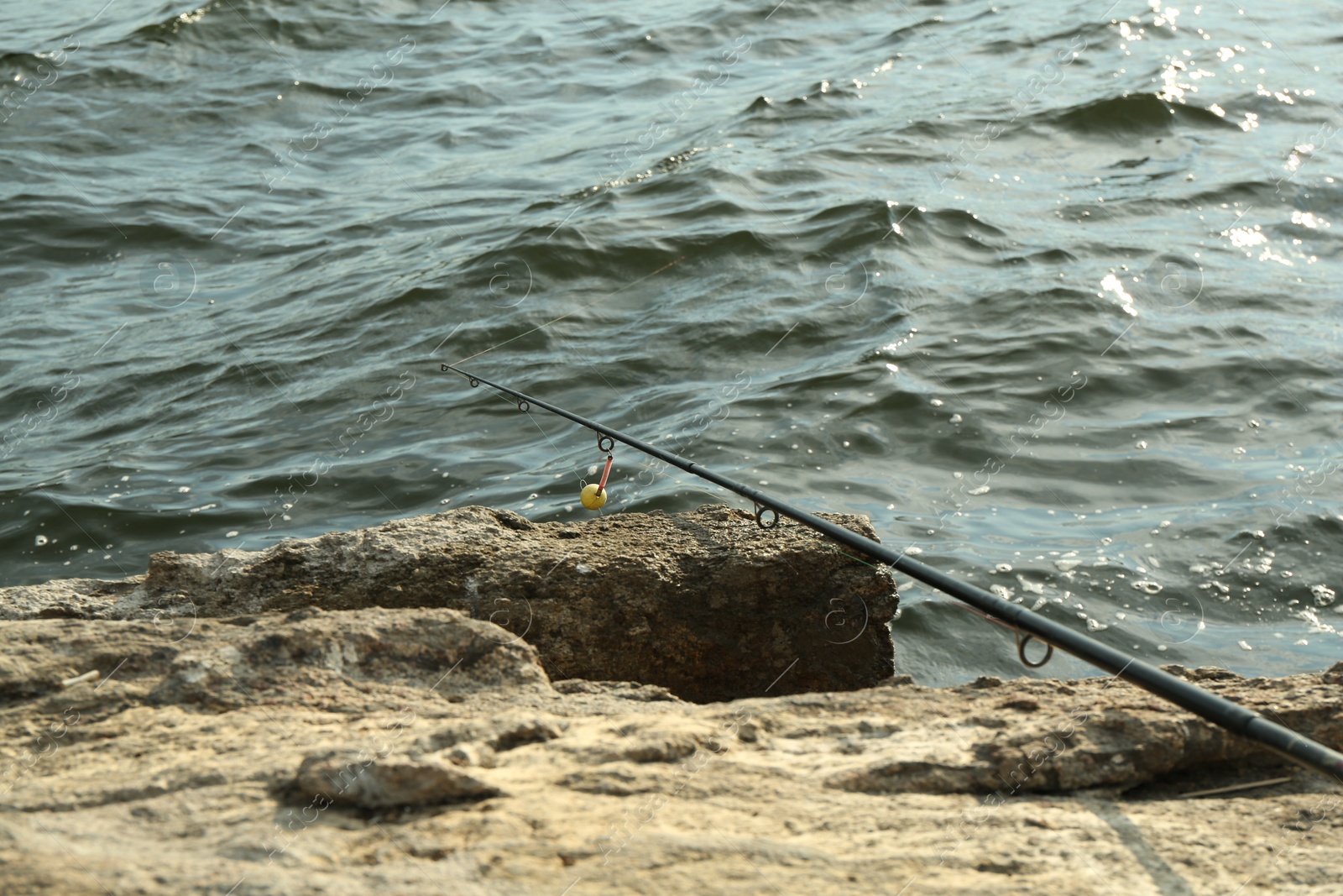 Photo of One fishing rod on shore near lake outdoors