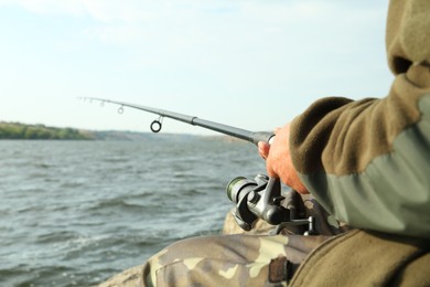 Fisherman with rod fishing near lake at summer, closeup