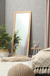 Large mirror near gray wall in room. Interior design