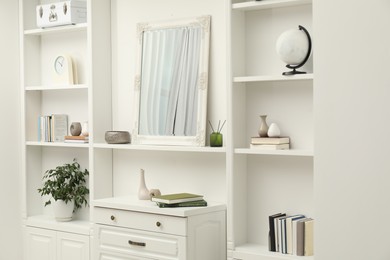 Mirror on white shelf in room. Interior design