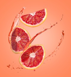 Image of Juice splashes and fresh red oranges in air on coral color background