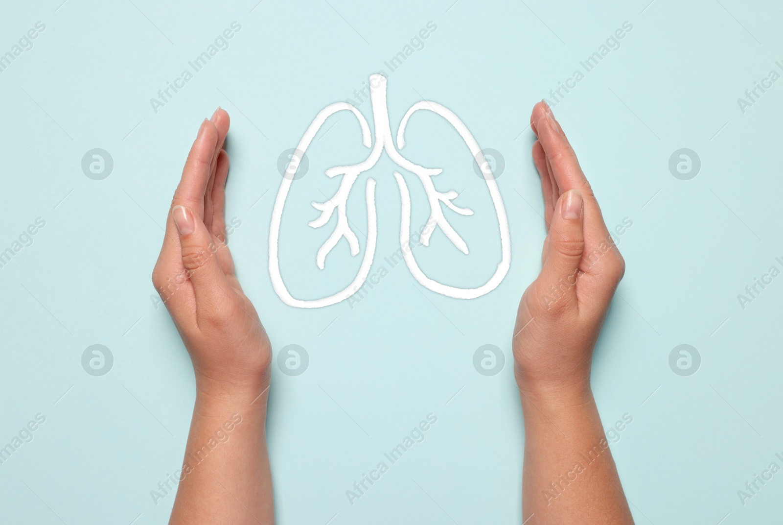 Image of Woman holding hands near illustration of lungs on light blue background, closeup. Asthma and other respiratory diseases