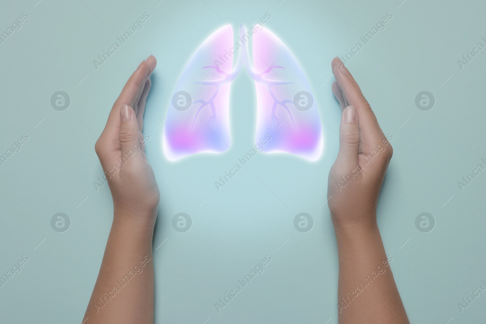 Image of Woman holding hands near illustration of lungs on light blue background, closeup. Asthma and other respiratory diseases