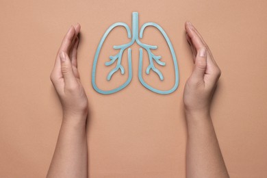 Image of Woman holding hands near illustration of lungs on color background, closeup. Asthma and other respiratory diseases